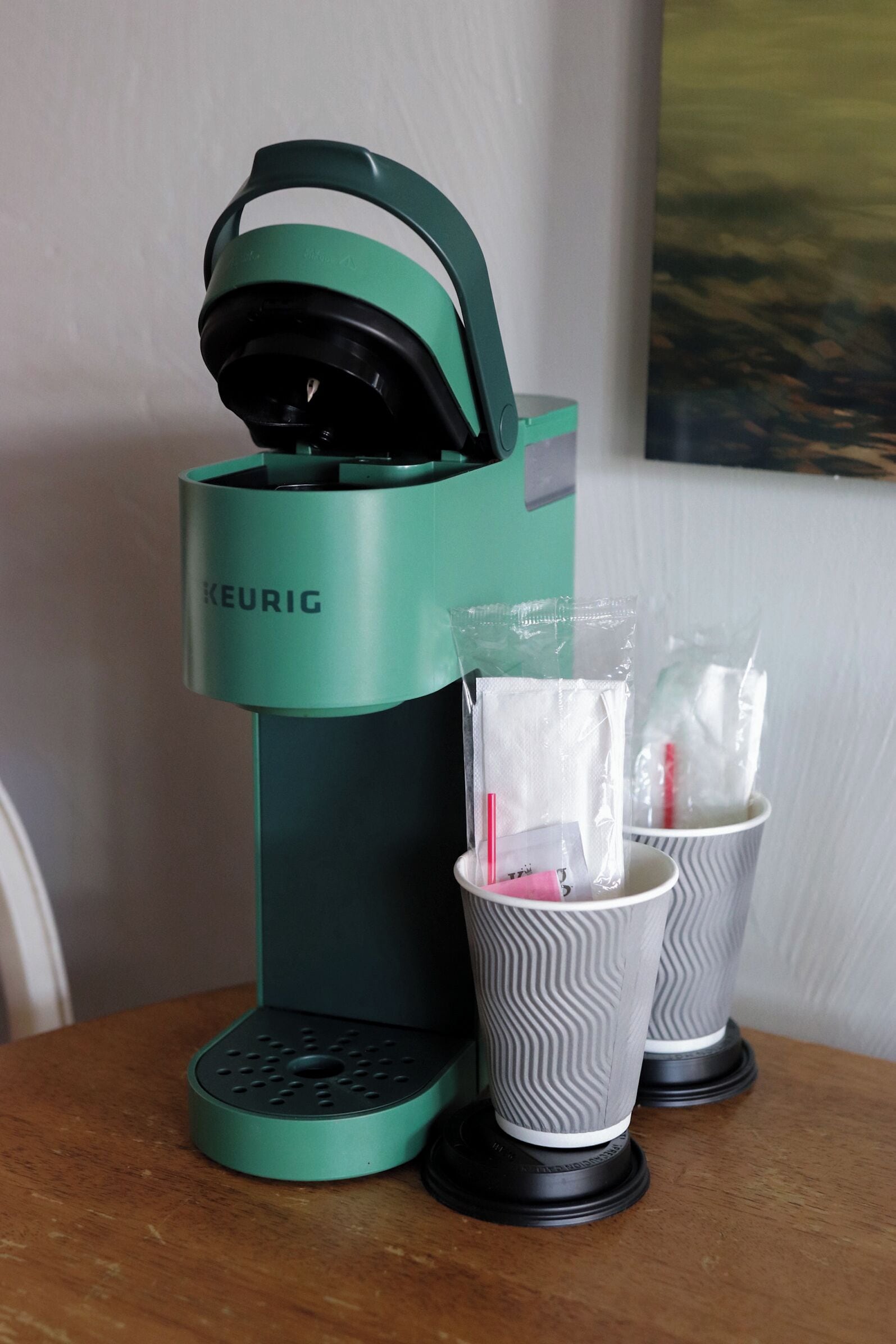 A Keurig coffee maker with two cups of coffee and a Keurig pod.