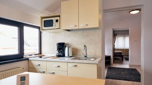 A compact kitchen with a microwave, coffee maker, and sink. - Modern Apartment (Brasov)