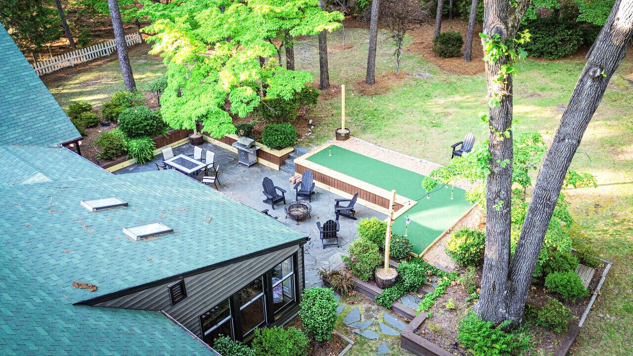 A rooftop patio with outdoor seating, a pool table, and a fire pit.