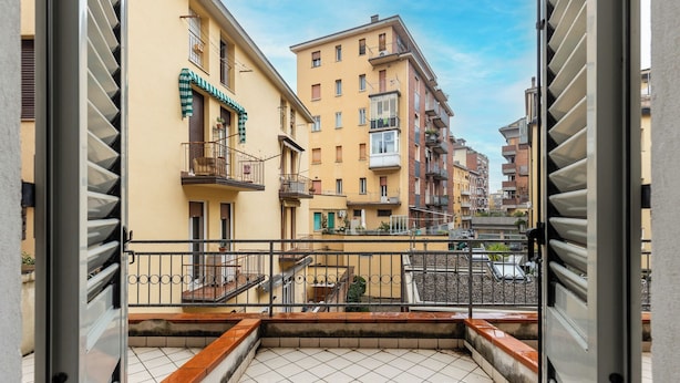 A balcony with a tiled floor, a metal railing, and a view of adjacent buildings. - Studio Calari alle Mura by Wonderful Italy (Bologna)