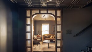 A hallway leading to a living room with a sofa, chairs, and a coffee table.