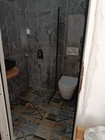 Un baño con ducha, inodoro y lavabo.