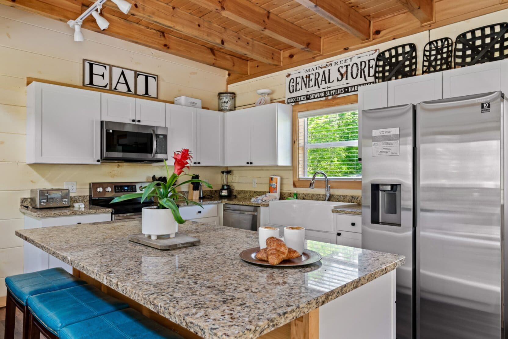A modern kitchen with granite countertops, stainless steel appliances, and a view of the outdoors.