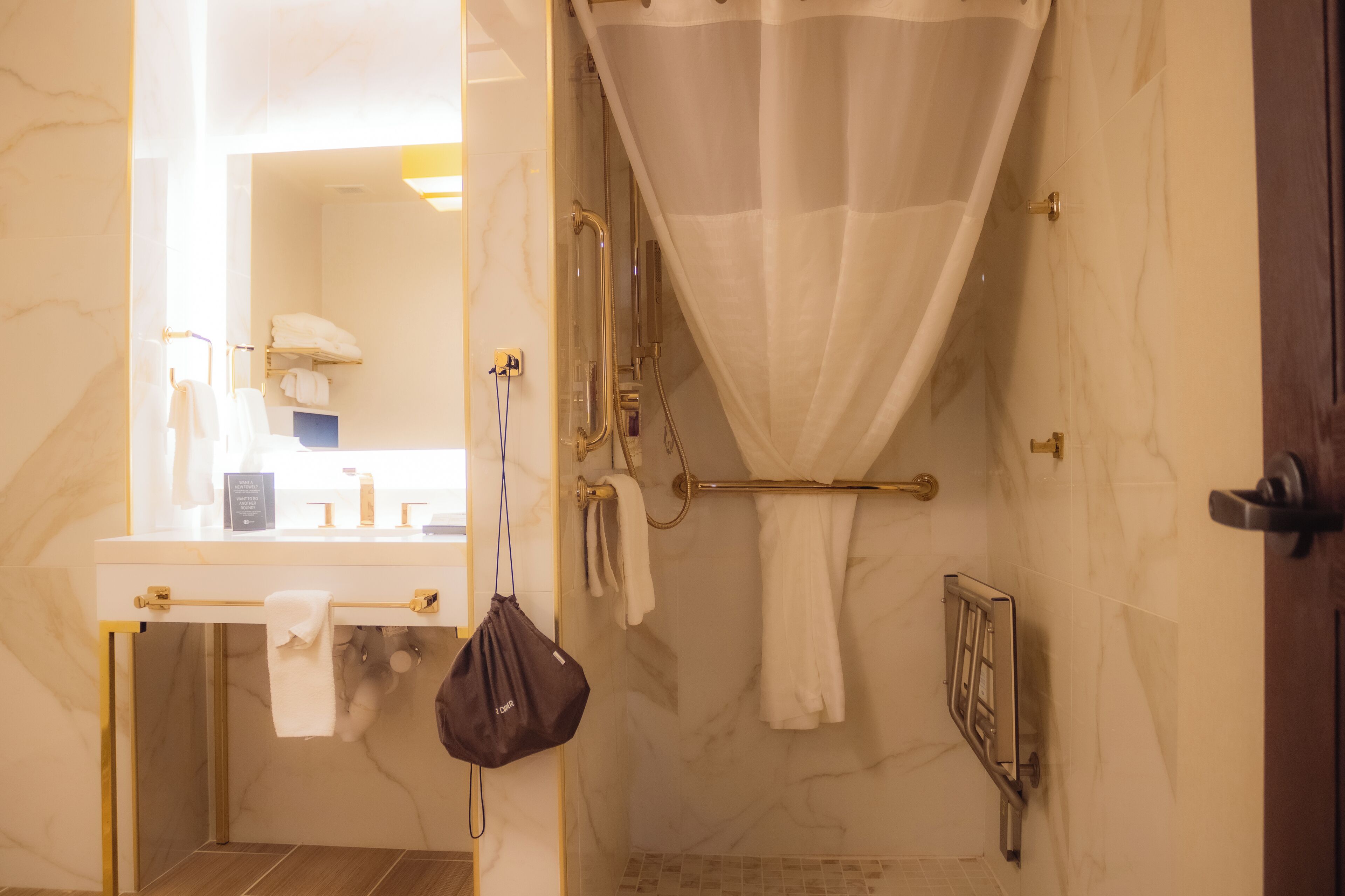 Ein Badezimmer mit Marmorwand, einer Dusche mit Glastür und einem Handtuchhalter.