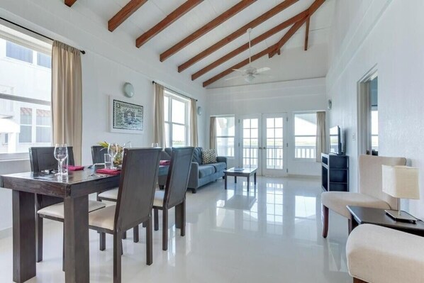 Relax in this spacious room with a dining area, sofa, and large windows.