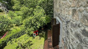 Un bâtiment en pierre avec un jardin et une chaise rouge.