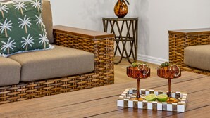Una sala de estar acogedora con un sofá, una mesa de centro con dos jarrones de cristal decorativos y un cojín estampado.