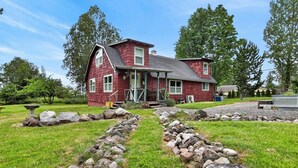 Une maison rouge avec un chemin de pierre menant à la porte d’entrée.