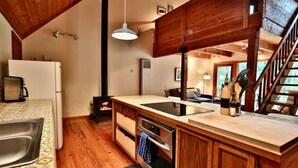 Una cocina con armarios de madera, una isla grande con pileta y horno empotrado.