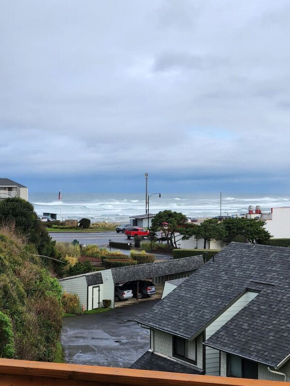 A residential area with houses, a road, and a view of the ocean under a cloudy sky. - L`escapade -The Getaway (Lincoln City)