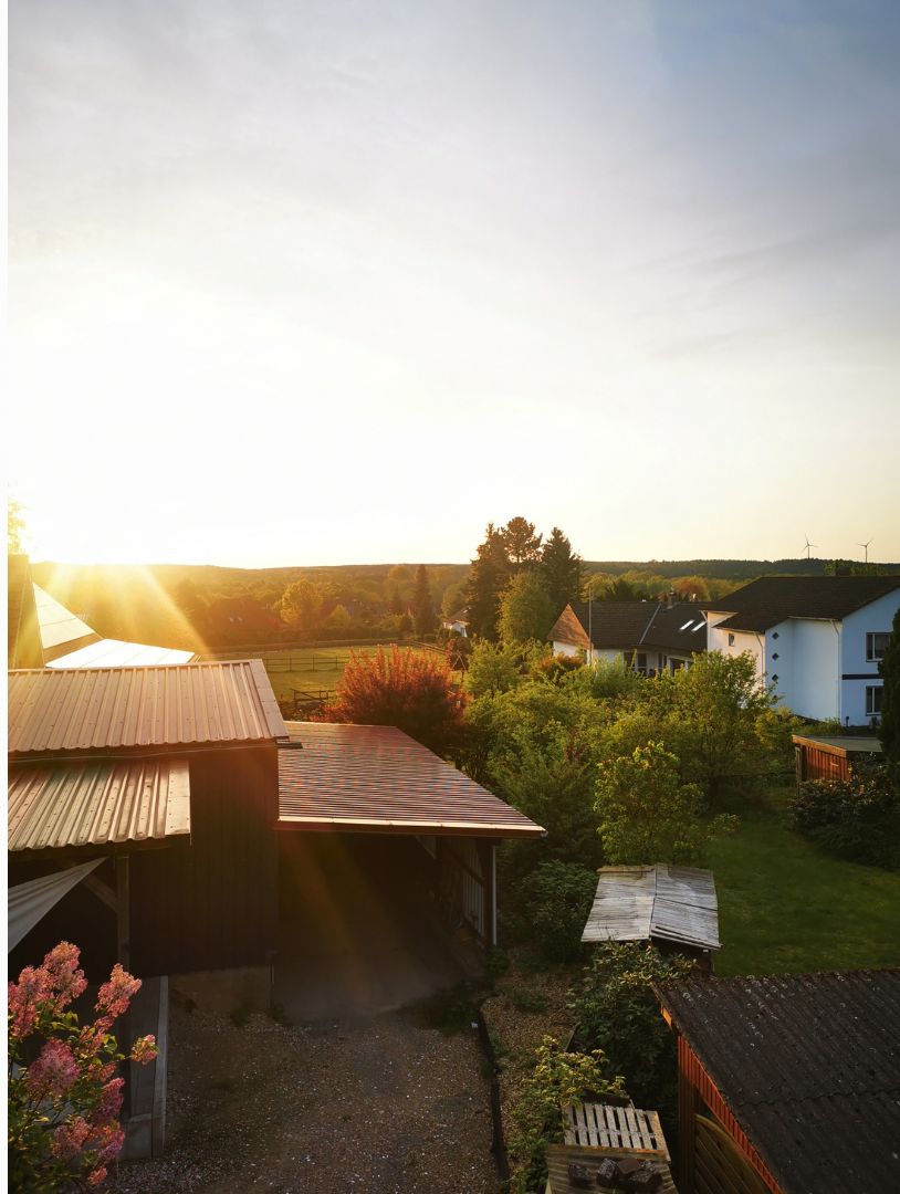 Ein Wohngebiet mit Häusern, einem Garten und blauem Himmel.