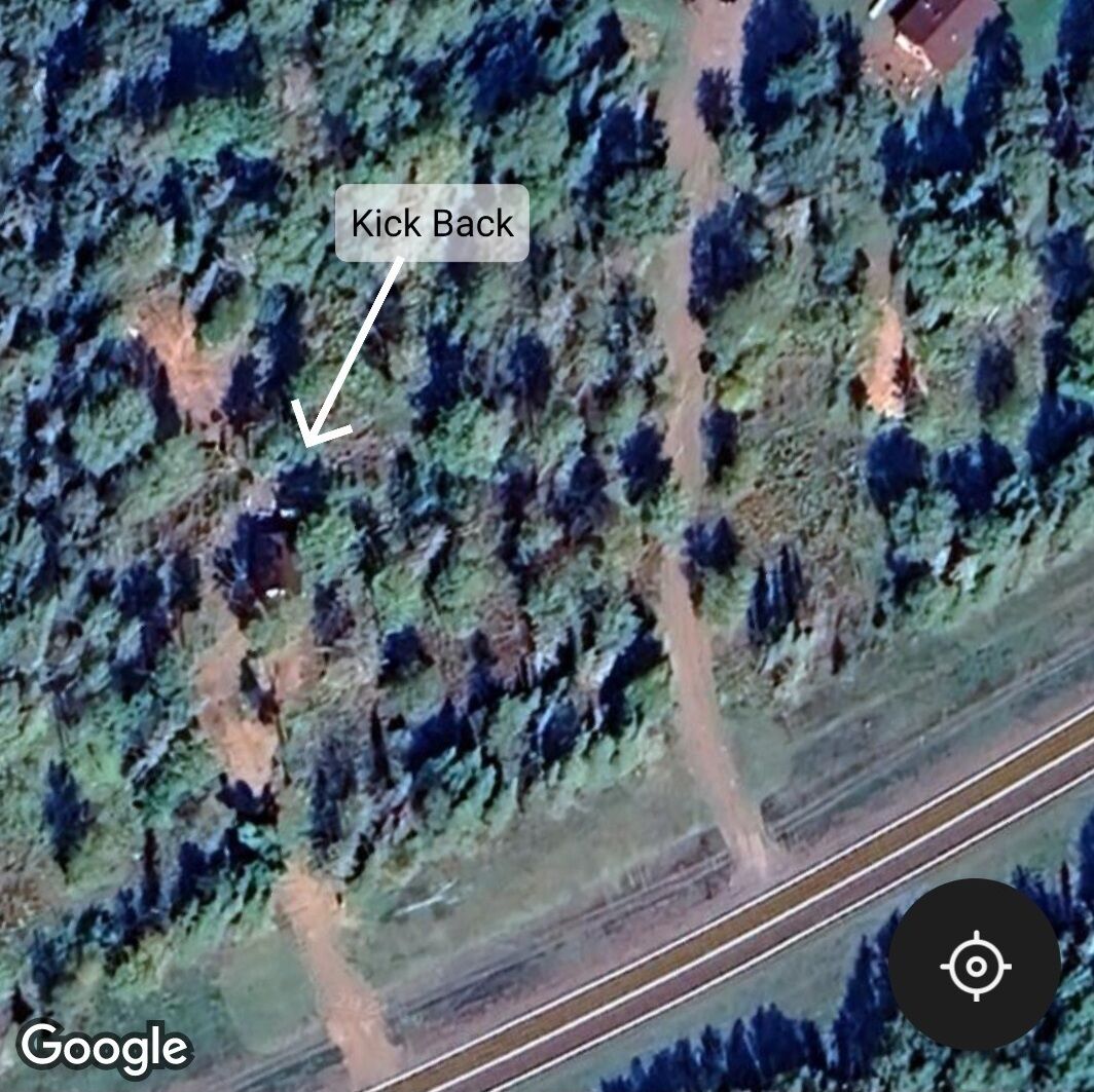 Vista aerea di una zona boschiva con un sentiero segnalato, con la scritta 'Kick Back'.