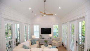 A spacious living room with a white sofa, a coffee table, and a TV. - 30A Fun in the Sun 5 minute walk to a Public Beach no Private Beach Hassles (Santa Rosa Beach)