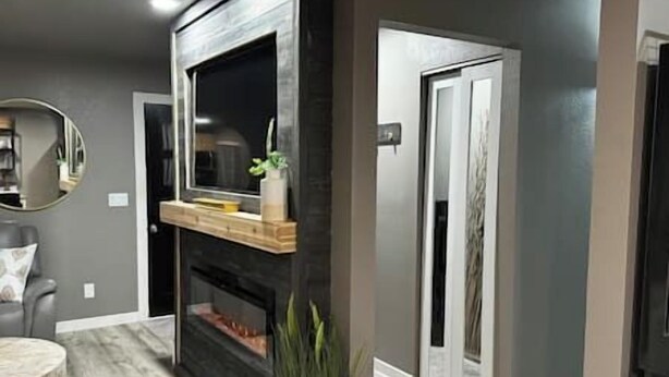 A modern living room with a fireplace, a mirror, and a seating area. - Oasis in The City - Executive Retreat- Long Term Welcome (Grand Junction)