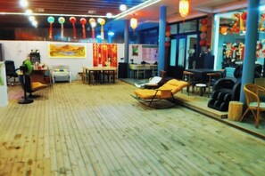 A room with a wooden floor, a sofa, a table, and a chair. There is a window and a door.