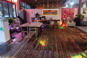 Huoneessa on puulattia, ruokapöytä, sohva ja televisio.