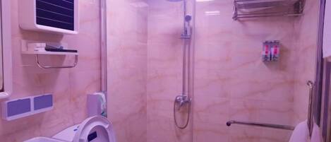 A bathroom with a glass-enclosed shower, a toilet, and a sink.