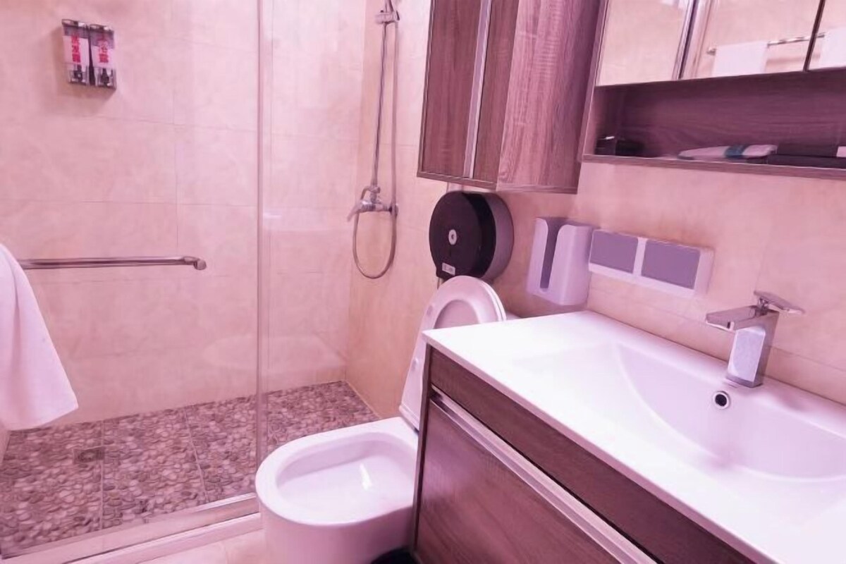Een badkamer met douche, toilet en wastafel.