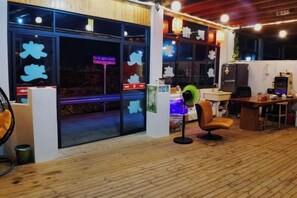 A restaurant with a wooden interior, a neon sign, and a counter with a green fan. - Yandang Mountain Yinshanju Vacation Apartment (Yueqing)