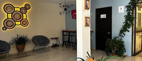 A modern interior with a wooden floor, a wall-mounted light fixture, and a door with a sign.