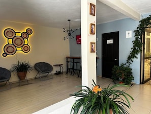 A modern interior with a wooden floor, a wall-mounted light fixture, and a door with a sign. - VOE HOTEL (San Cristóbal de las Casas)