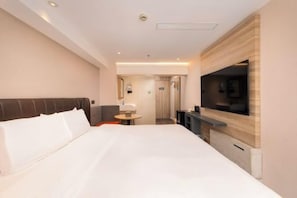 A hotel room with a large bed, a TV mounted on the wall, a small table, and a bathroom visible through an open door. - HanTing Premium Hotel (Shanghai Pudong Airport Chenyang Road) (Shanghai)