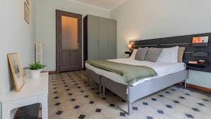 A bedroom with a bed, bedside table, lamp, and a door. - Appartamento Agnelli vicino al Pala Alpitour by Wonderful Italy (Turin)
