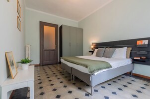 Una camera da letto con un letto, un comodino, una lampada e una porta.