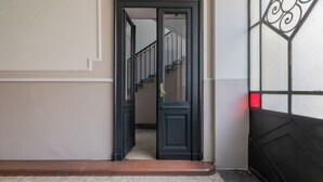 A hallway with a black door leading to a staircase. - Appartamento Agnelli vicino al Pala Alpitour by Wonderful Italy (Turin)