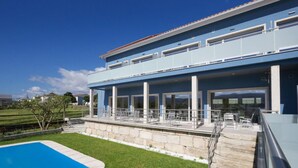 A modern two-story house with a covered patio area, a swimming pool, and a stone retaining wall. - Refúgio da Garça (Chaves)