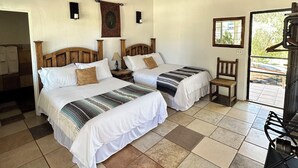 A room with two beds, a ceiling fan, a window, and a door leading outside. - Casa Luna Viñedo (Valle de Guadalupe)