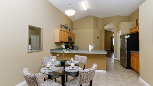 A modern kitchen with a dining area. - Beautiful 4 Bedroom Villa near Disney World with Private Pool (Kissimmee)