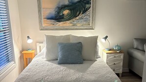 Ein Schlafzimmer mit einem Bett, zwei Nachttischen, einem Fenster mit Jalousien und einem Bild.