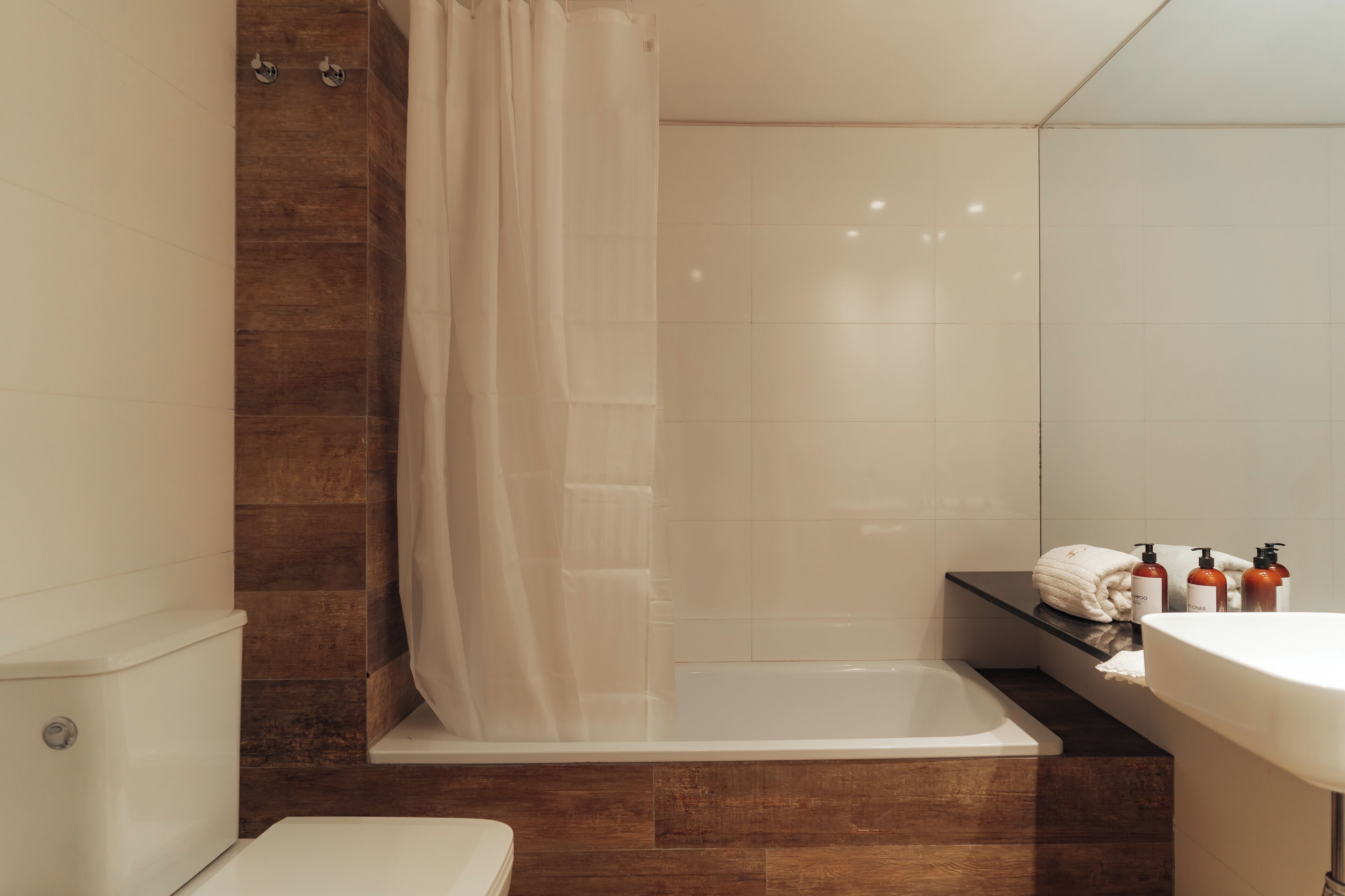 A modern bathroom with a bathtub, toilet, and sink.