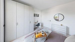 Un dormitorio moderno con un amplio armario, un escritorio y una mesita de noche con una bandeja de desayuno.