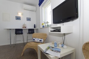 Enjoy a functional space with a flat-screen TV, wicker chair, and dining area.