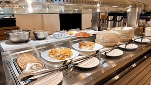 A buffet setup with various dishes, including bread, pastries, and a large wicker basket. - Aloha Palace (Jijoca de Jericoacoara)