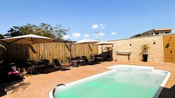 A rectangular swimming pool with a white edge, surrounded by a wooden deck.