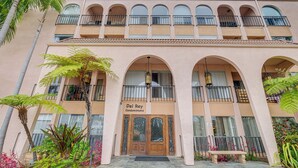 A multi-story building with a central entrance, balconies, and a sign reading "Del Rey Condominiums". - Condo Near Hospitals & 1/2 Mi to Mission Bay! (San Diego)