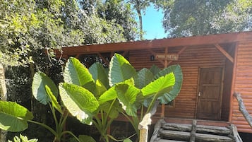 A wooden cabin with a stone staircase leading to a door labeled 'Maria Preta.'