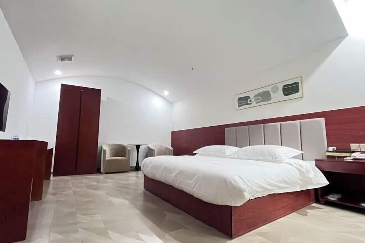 Ein modernes Schlafzimmer mit einem großen Bett, einem Schreibtisch und einem Sessel.