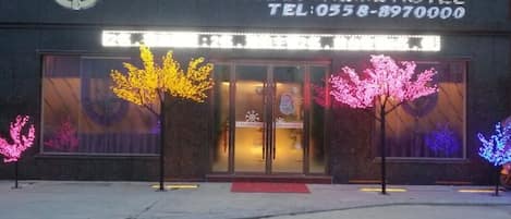The exterior of the Alex Hua Tian Theme Hotel with a clear entrance and signage.