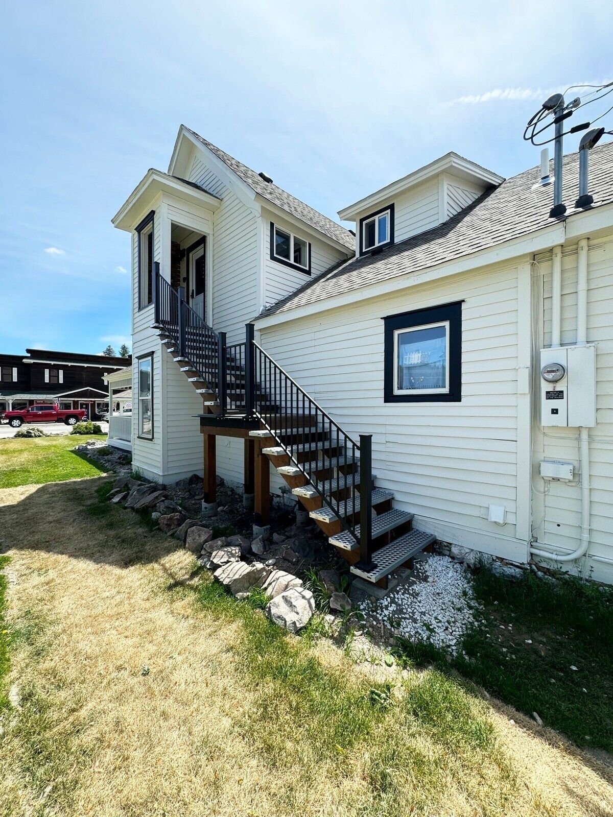 A two-story house with a black staircase leading to the upper floor.
