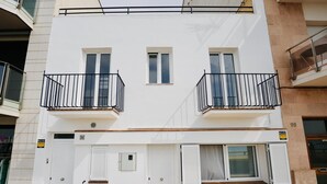 A two-story building with balconies, a door, and windows. - Mundet 4 Dalt Terrassa. CostaBravaSi - At the sea (Sant Antoni de Calonge)