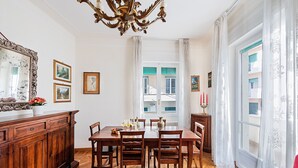 Ein Esszimmer mit Holztisch und Stühlen, einer Chandelüster und einem großen Spiegel an der Wand.