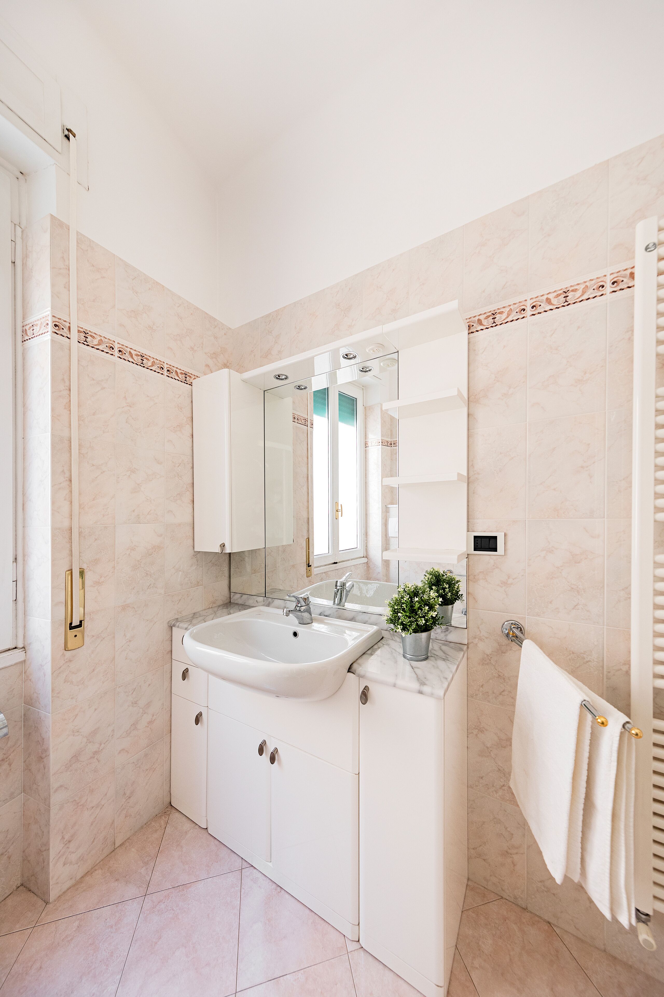 Une salle de bain moderne avec un lavabo en marbre, un grand miroir et un porte-serviettes.