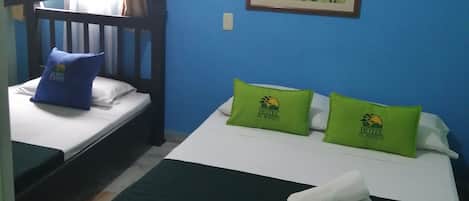 A hotel room with two beds, one with a bunk bed, and a painting on the wall.