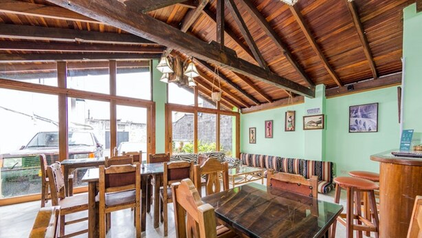 A rustic dining area with wooden furniture and a high ceiling. - HOTEL EL BOSQUE ARMENIA (Armenia)