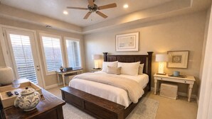 A bedroom with a bed, bedside tables, a desk, a ceiling fan, and a window with blinds. - Get together at Zion`s Gate l & ll! (Washington)