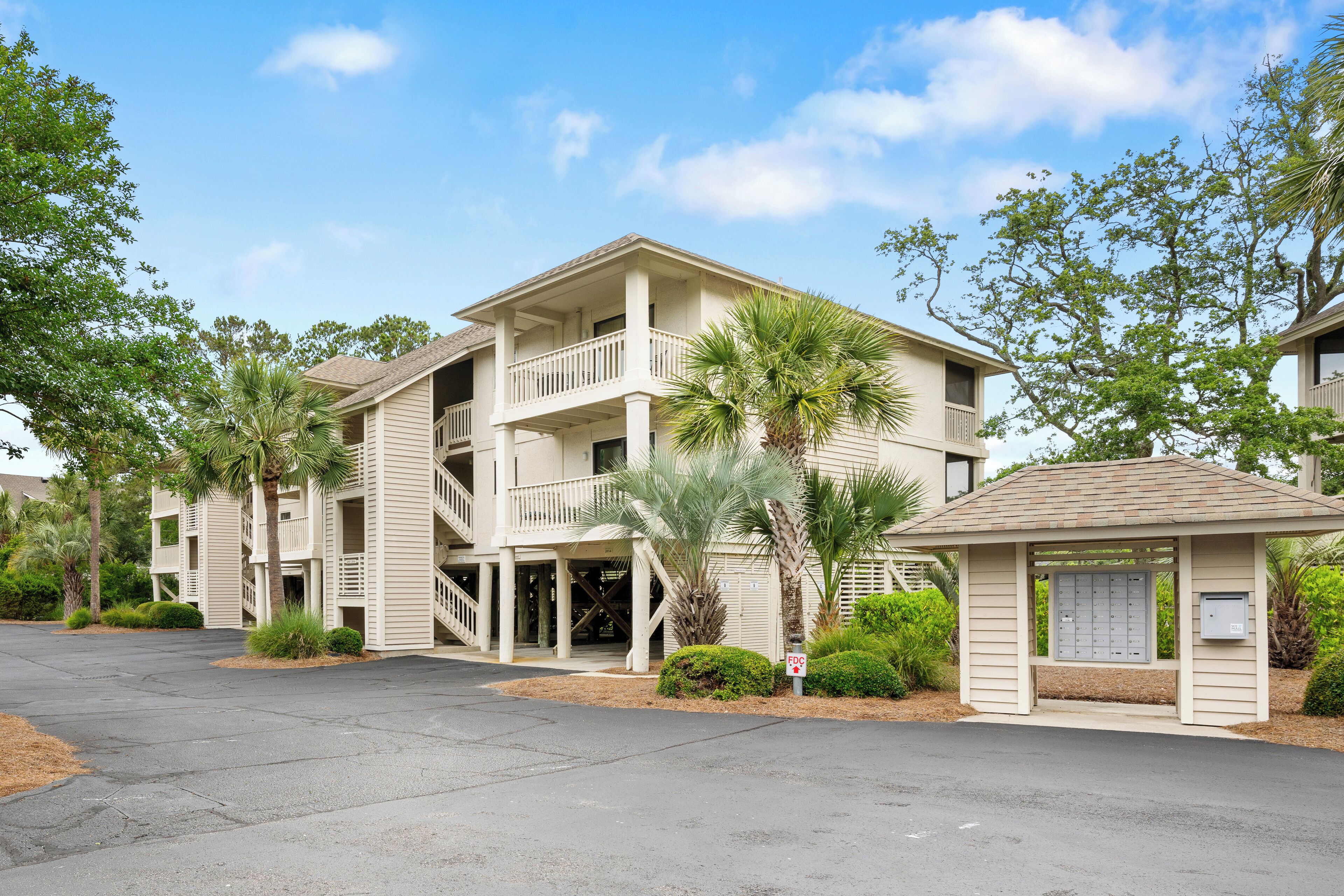 A multi-story hotel with a central courtyard, balconies, and palm trees.